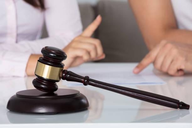 istock Couple Having Discussion Over Document In Courtroom 908785966