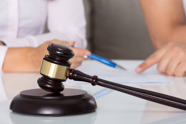istock Couple Having Discussion Over Document In Courtroom 908785978
