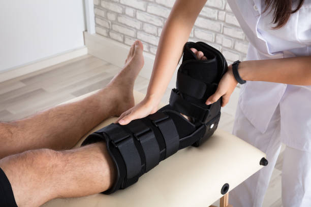 istock Orthopedist Putting Walking Brace To Patient's Leg 908786026