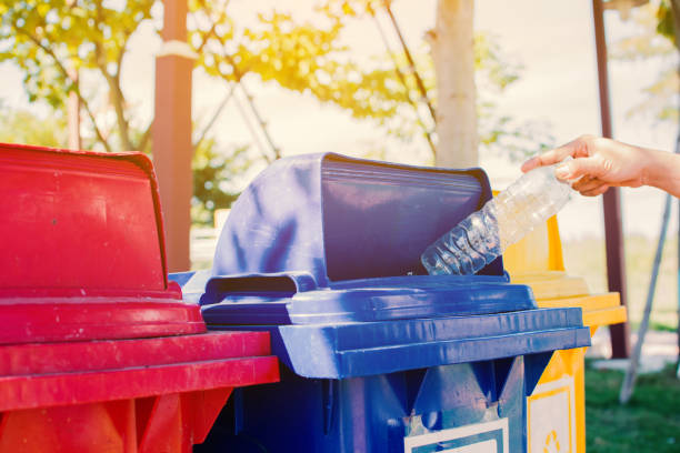 istock Cropped Hand Of Person Throwing Plastic Bottle In Garbage Bin 908786482