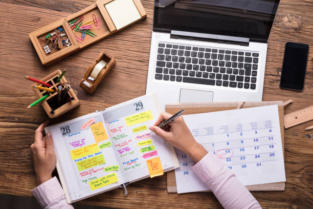istock Businesswoman Writing Schedule In Calendar Diary 908787210