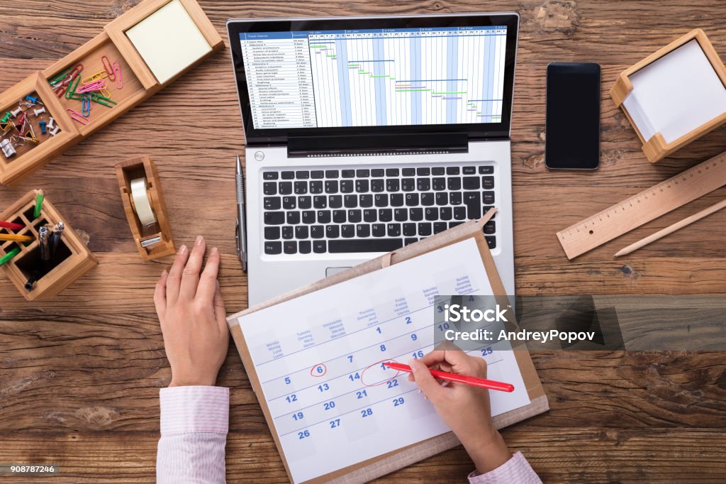 Business Woman Marking A Date On Calendar Businesswoman Marking A Date On Calendar At Workplace Calendar Stock Photo