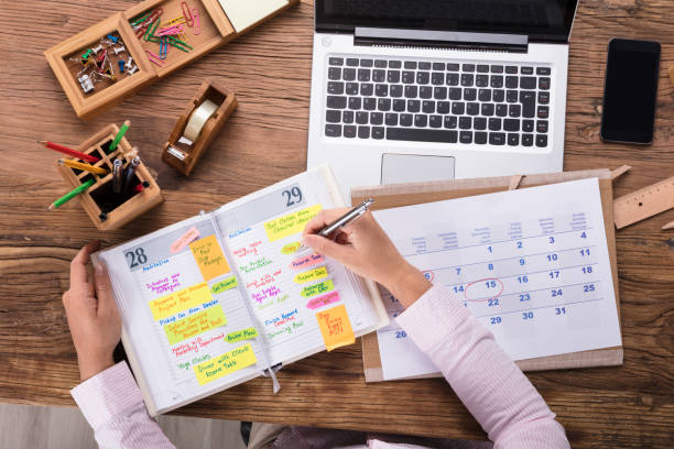 istock Businesswoman Writing Schedule In Calendar Diary 908787250