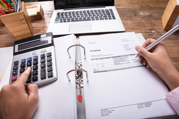 istock Businesswoman Calculating Invoice On Desk 908787270