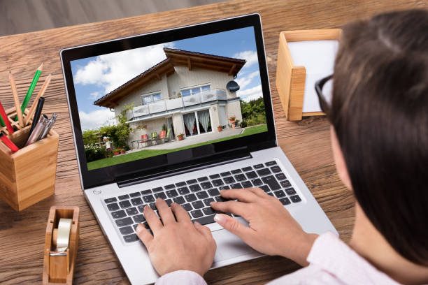 istock Woman Looking At House On Laptop 908787344