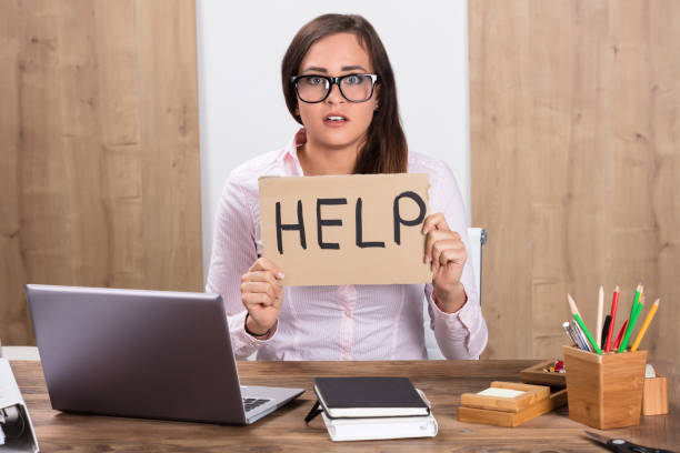 istock Businesswoman Holding Help Sign At Workplace 908787446