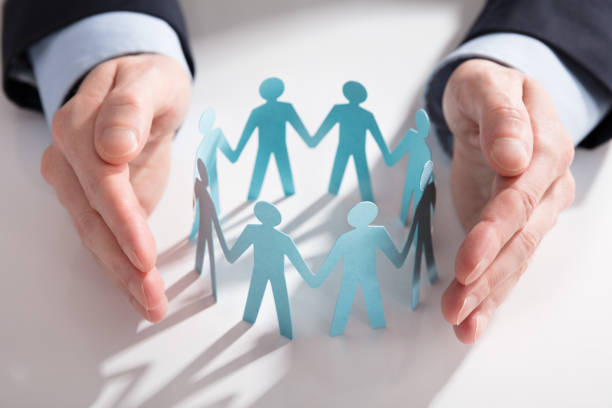 istock Businessperson's Hand Protecting Paper Cut Out Figures 908800800