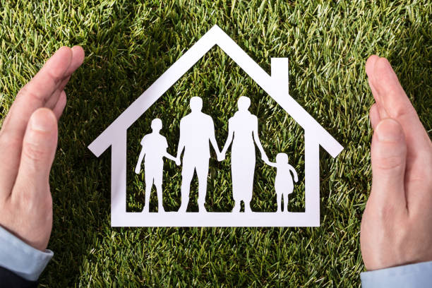 istock Person Holding Family Home On Grass 908800866