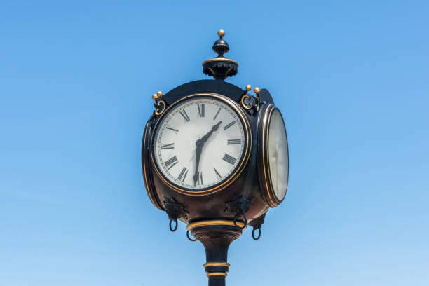 istock Low Angle View Of Clock Against Clear Blue Sky 908813762