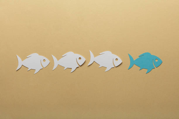 Paper Fishes In A Row Over Pale Brown Background