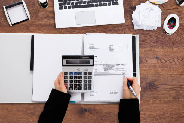 istock Businessperson's Hand Calculating Bill In Office 908821308