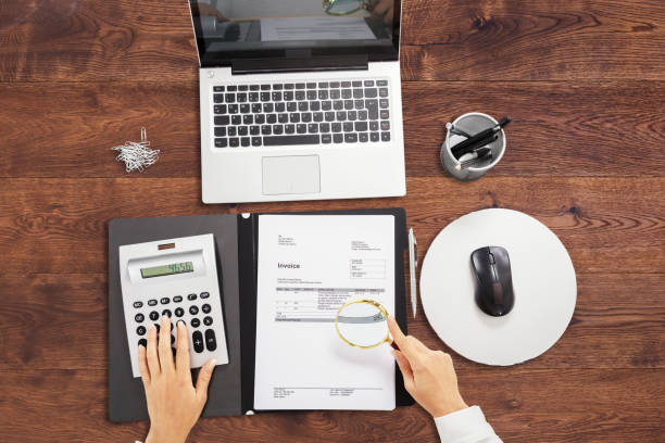 istock Businessperson Analyzing Bill With Magnifying Glass 908821312