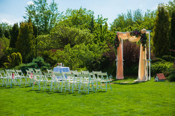 istock Wedding arch and white chairs in garden 908821554