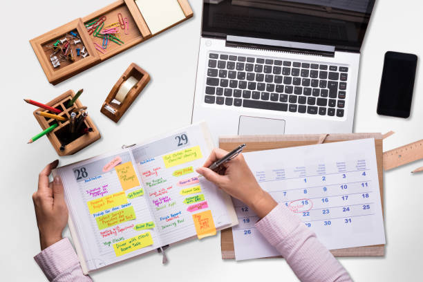 istock Elevated View Of A Businessperson Writing Schedule In Diary 908827804
