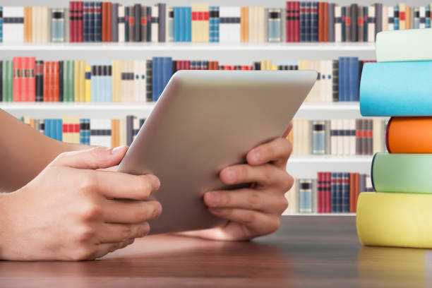 Close-up Of Person Hand Holding Digital Tablet At Desk