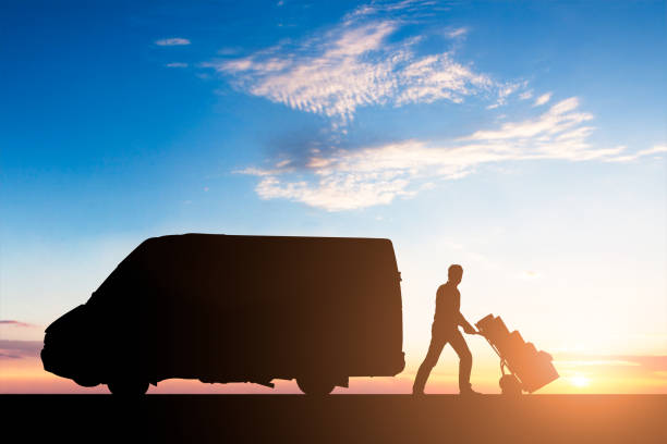 istock Silhouette Of Delivery Courier With Cardboard Boxes On Trolley 908830732