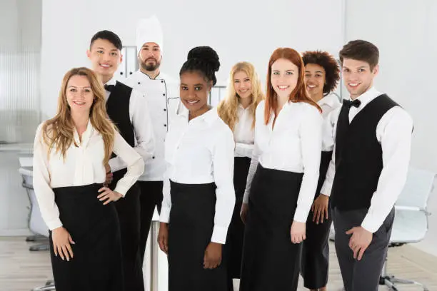 Portrait Of Confident Restaurant Staff Standing Against White Background