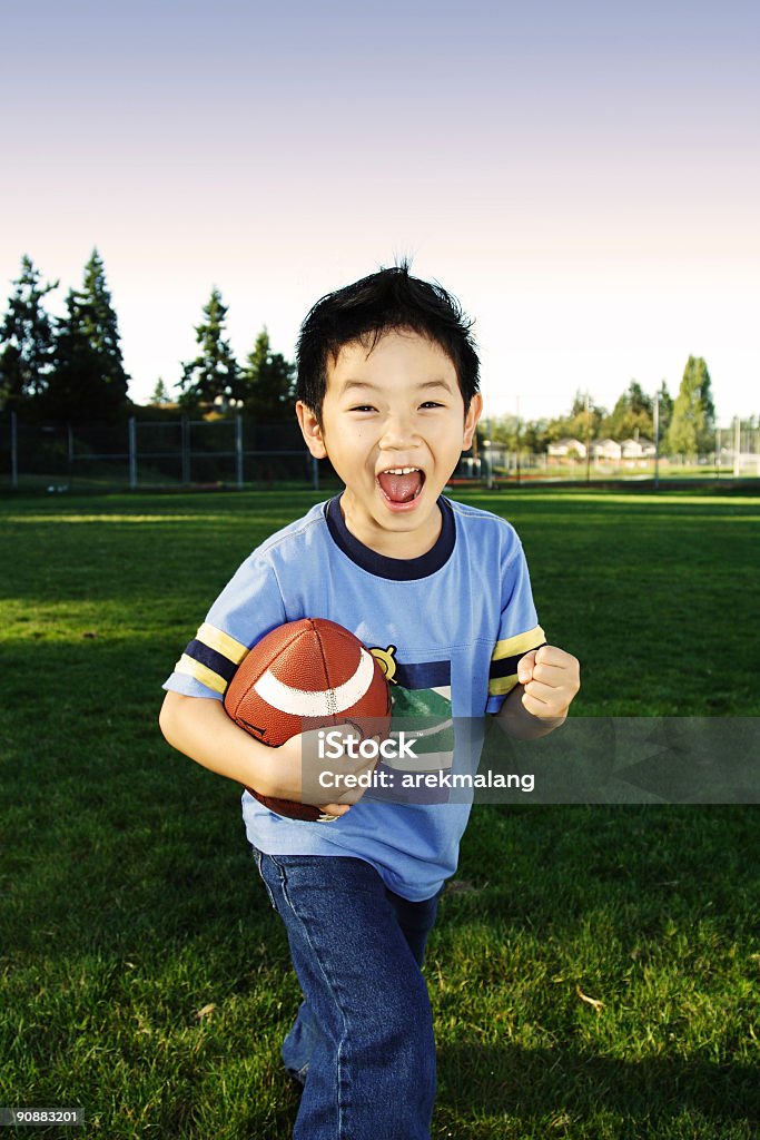 サッカー少年 - アメフトボールのロイヤリティフリーストックフォト