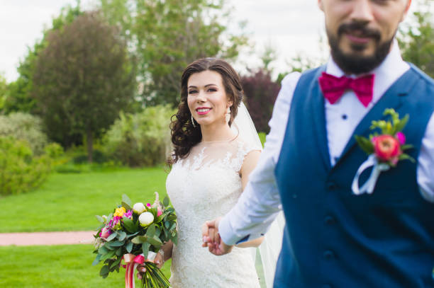 istock Groom holding hand of his smiling happy bride 908834270