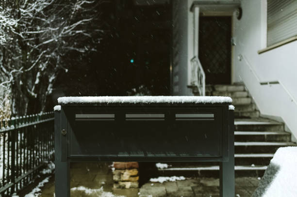 Postal boxes in front of the house - snowing calmly on a cold winter night
