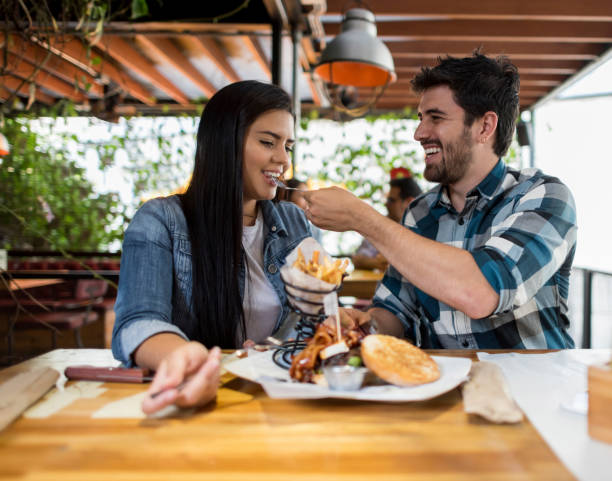 istock Young couple eating together at a restaurant 908849896
