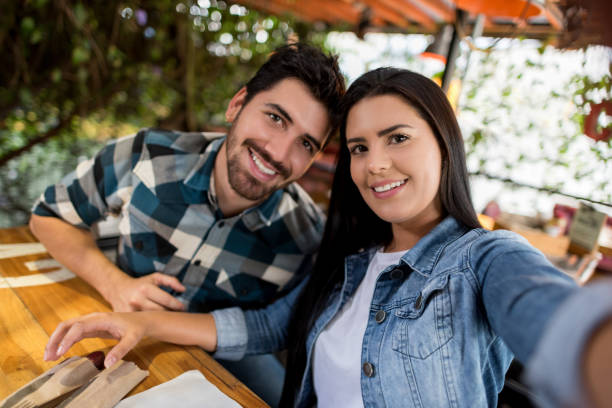 istock Happy couple taking a selfie at a restaurant 908849958
