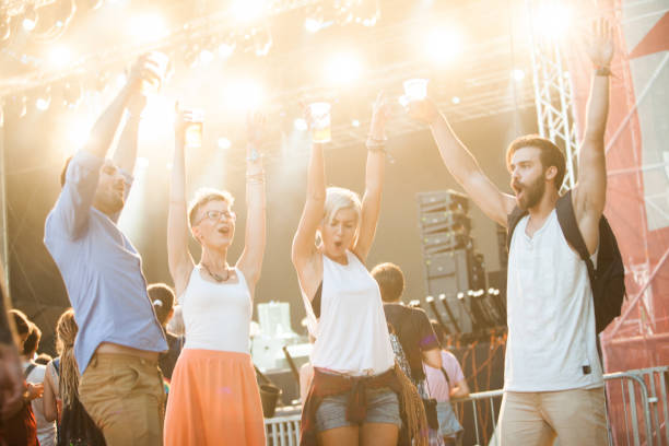 istock Four people dancing and drinking beer on festival 908850698