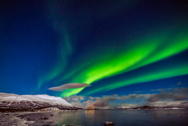 winter: awesome aurora borealis appears over tornetrask lake and mount nuolja in swedish lapland - mountain reflection non urban scene moody sky imagens e fotografias de stock