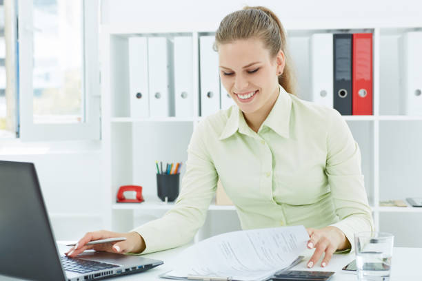 istock Beautiful young smiling secretary make notes sitting at office. Business, exchange market, job offer, analytics research, excellent education, certified public accountant concept 908856430