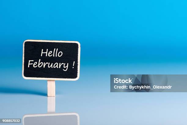 Hello February Words On Little Wooden Tag At Blue Background With Empty Space For Text Template Or Mockup Stock Photo - Download Image Now