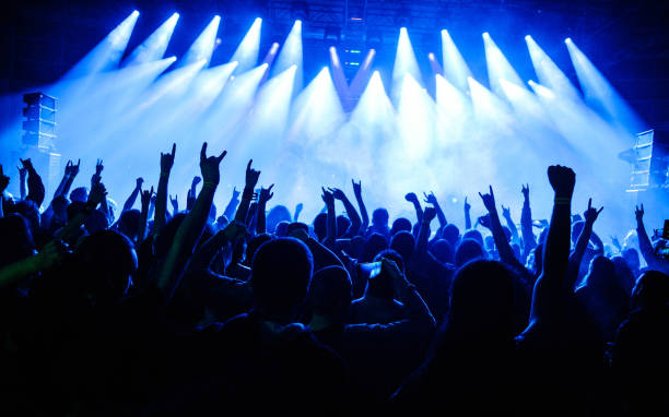 istock Crowd raising hands in the air on concert 908862620