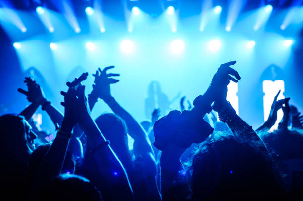 istock Crowd raising hands in the air on concert 908862784