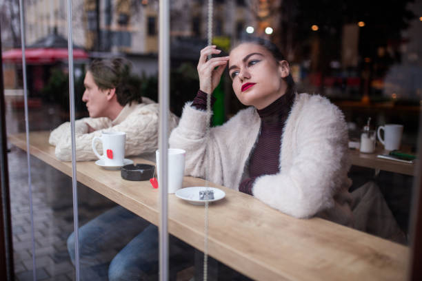 istock Unhappy Couple Sitting At Cafe And Breaking Up 908872308