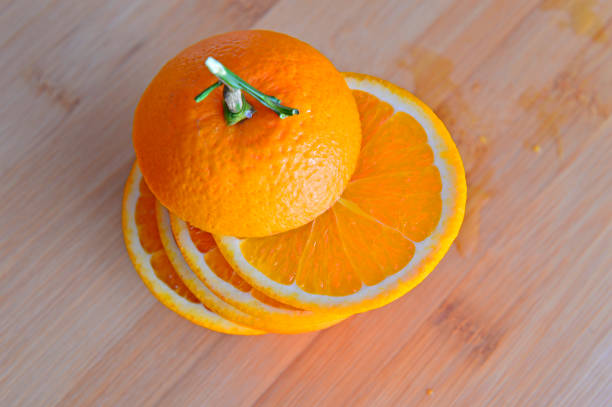 istock Orange isolated in wooden background 908875382
