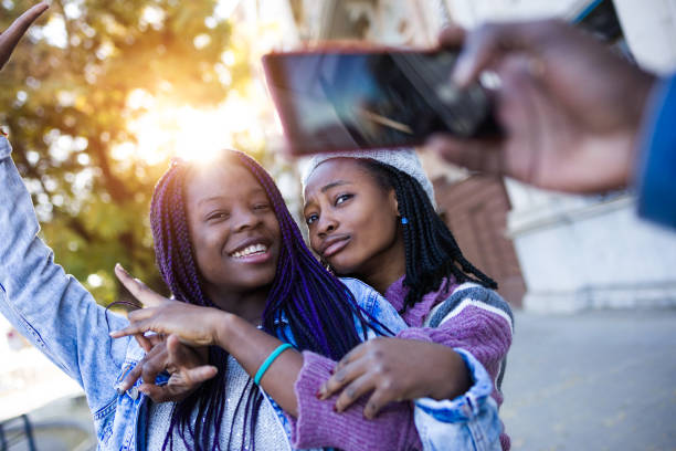 istock Group of three friends using mobile phone in the street. 908888300