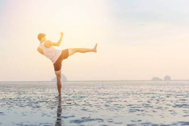 istock Young asian man training karate and kick boxing at the beach 908894262