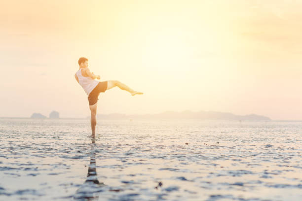 istock Young asian man training karate and kick boxing at the beach 908894292