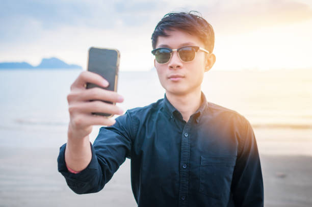 istock Relaxing Businessman using  laptop and smartphone on the beach 908895216