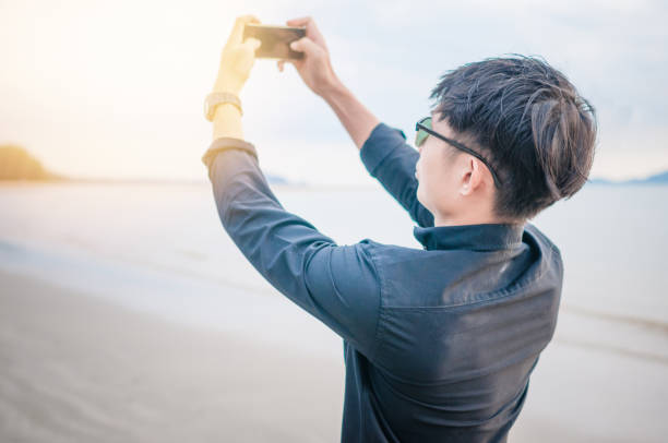 istock Relaxing Businessman using  laptop and smartphone on the beach 908895270