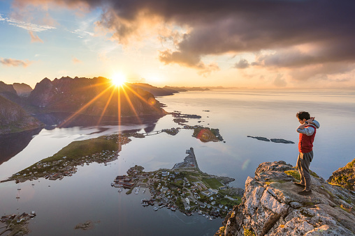 Traveller enjoy summer view of Lofoten Islands in Norway with sunset scenic