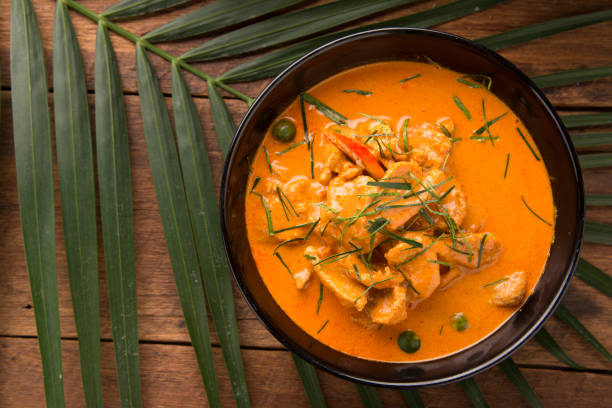 thai curry soupe rouge, curry de tradition rouge de thaïlande avec menu de bœuf, de porc ou de poulet au nom thaï est lopes. menu curry au lait de coco. panaeng curry sur table en bois - panang curry photos et images de collection