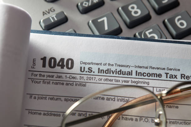 istock Income tax docs with glasses 908909594