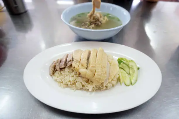 Photo of Steamed chicken and white rice, (Hainanese Chicken Rice) served with soup, Thai food recipe.