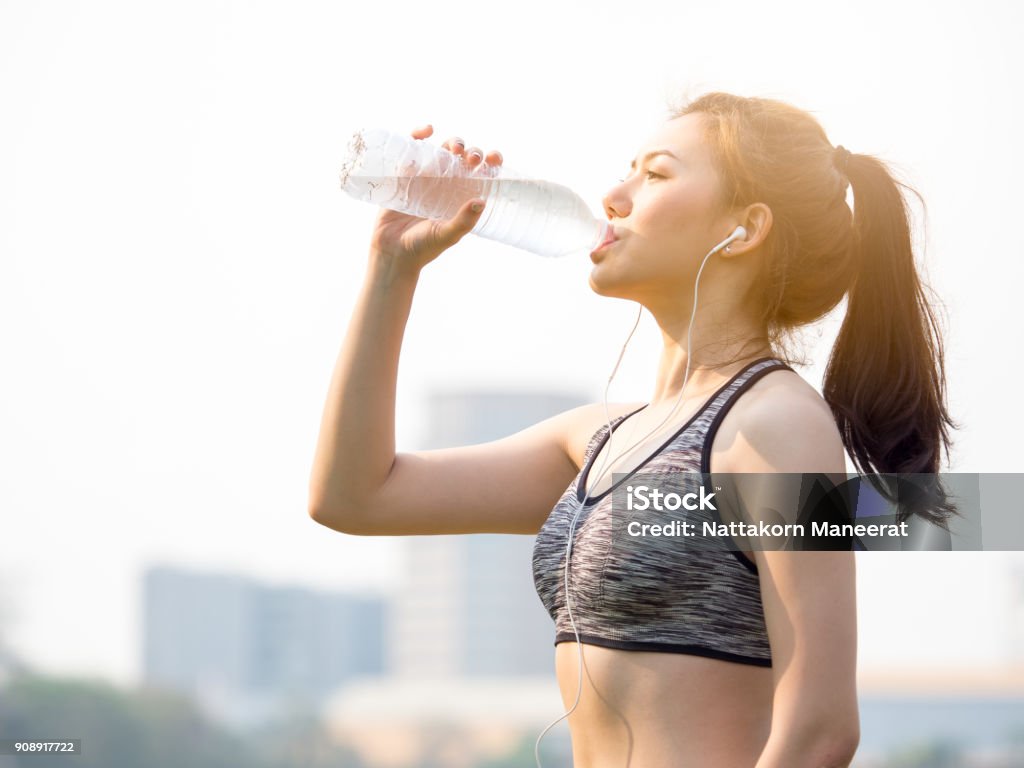 Conceito de outdoor fitness mulher, jovem mulher bela asiática água potável durante o treino, correr, correr, ioga no parque exterior, fresco, relaxe, feliz sensação - Foto de stock de Água royalty-free