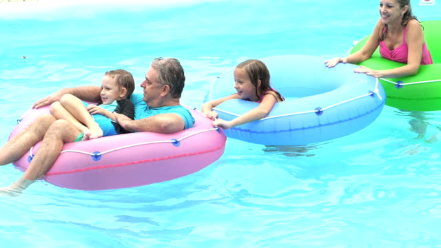 Children, grandparents on inflatable rings, lazy river
