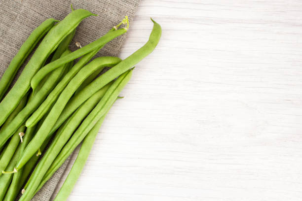 istock Green beans on sackcloth on wooden table 908924726
