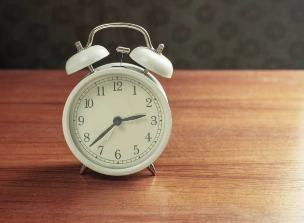 istock alarm clock on wooden. 908928296