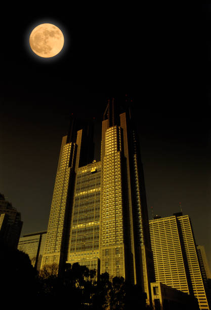 istock Full moon rising over the Tokyo Shinjuku skyscraper 908931446