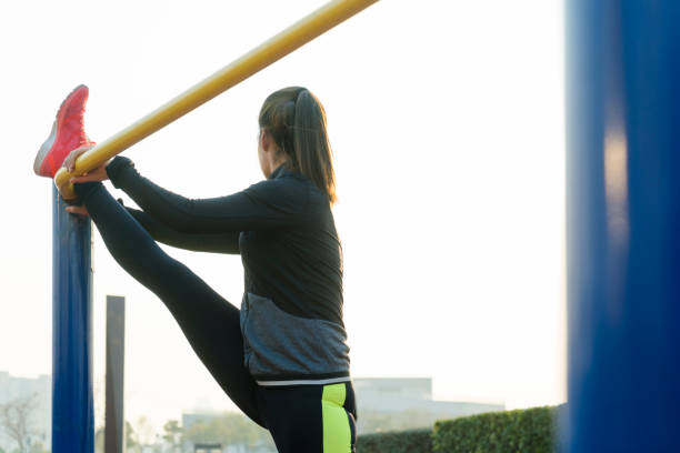 istock female athlete stretching her legs on horizontal bar 908932624