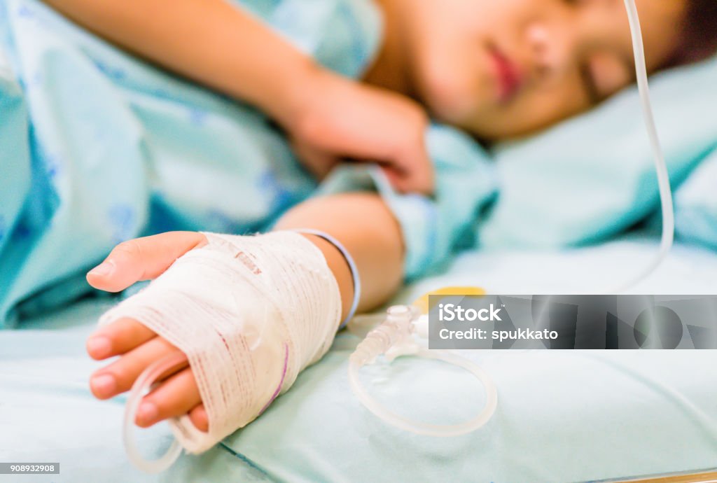 Mão de criança closeup dorme numa cama de hospital com solução salina intravenosa. - Foto de stock de Criança royalty-free